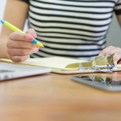 close-up-das-maos-de-escrita-em-uma-prancheta